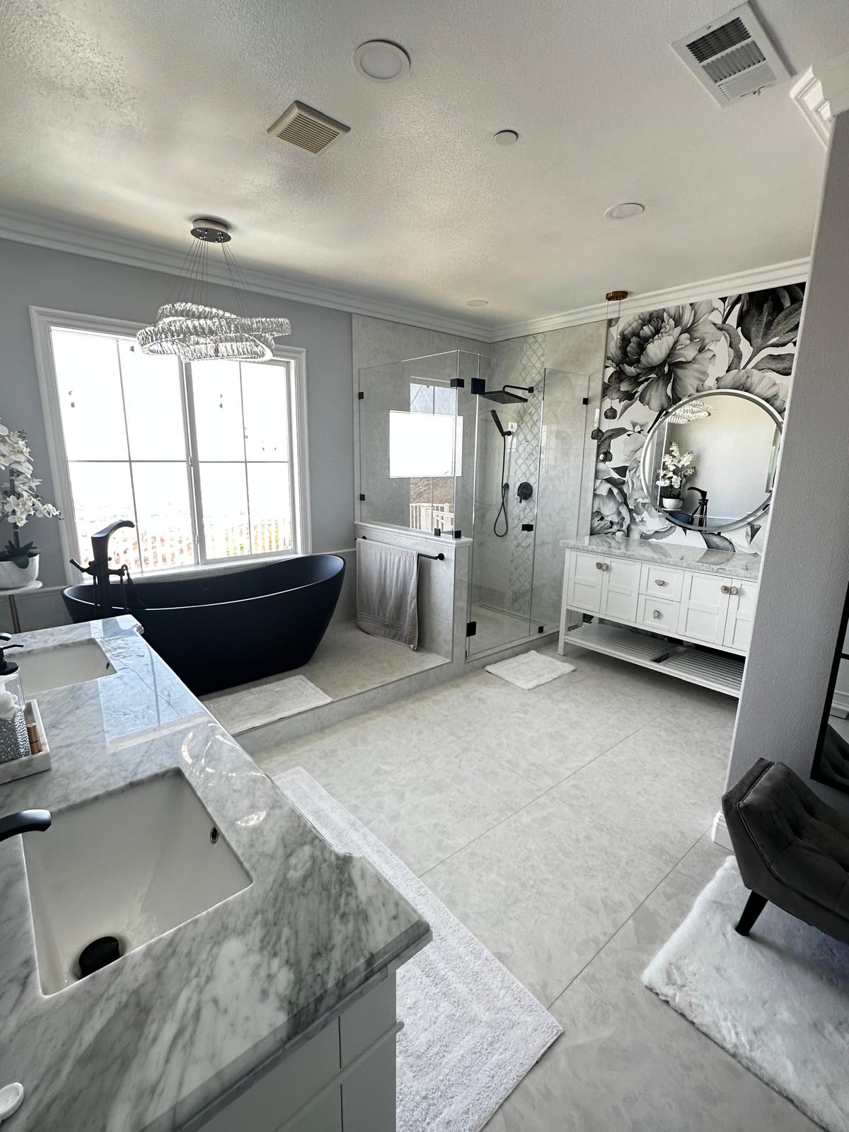 Spacious master bathroom remodel with black freestanding tub, walk-in glass shower and double marble vanity